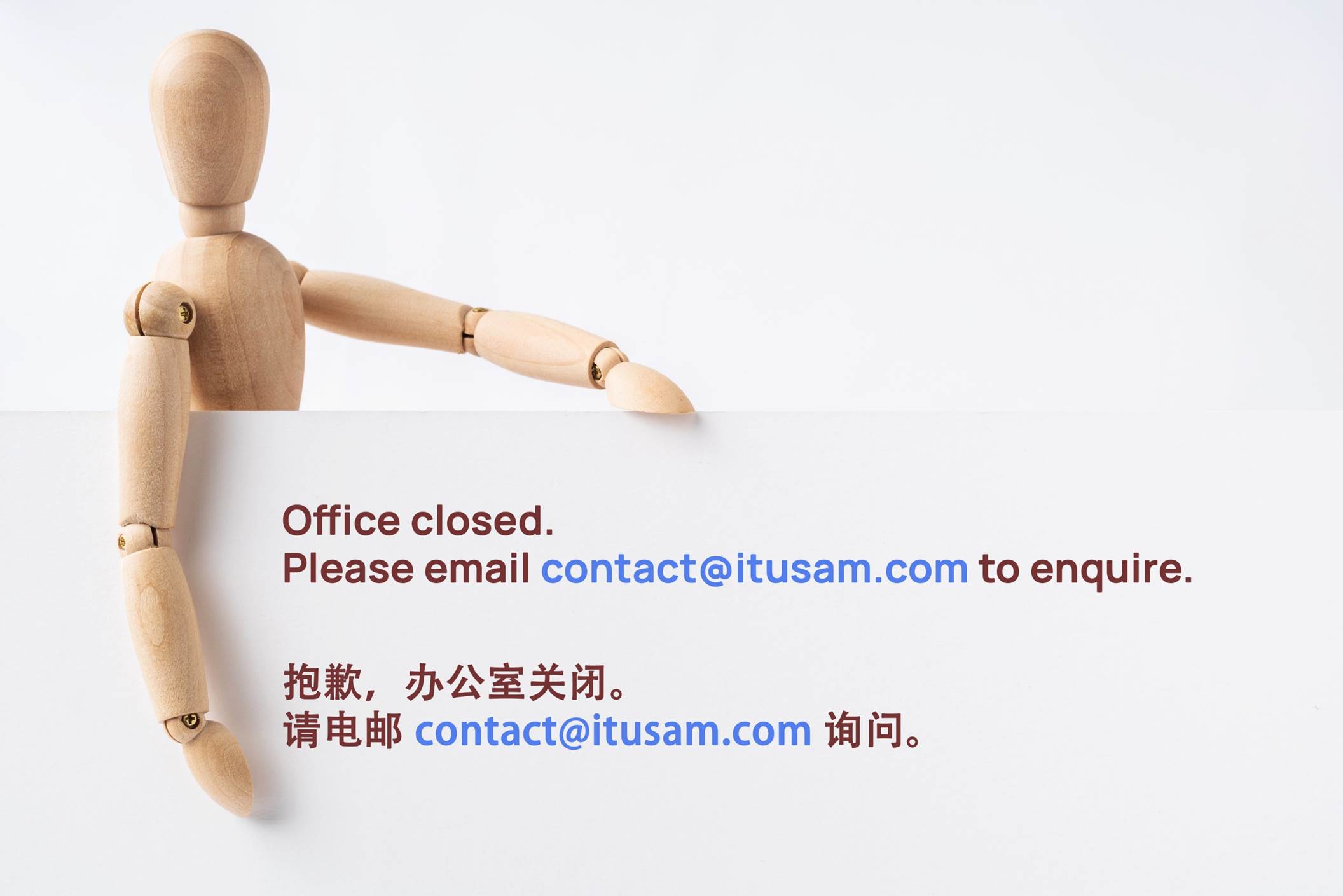 A wooden doll holding a business card

Description automatically generated